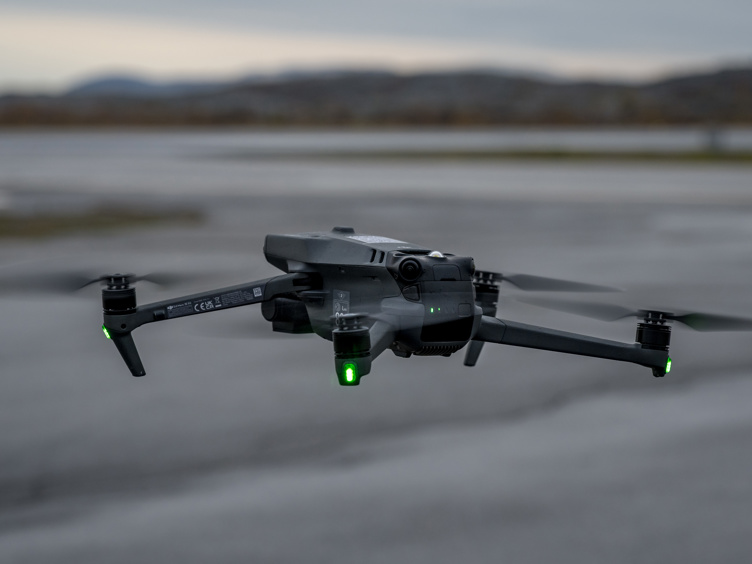 Grå drone som flyr i luften